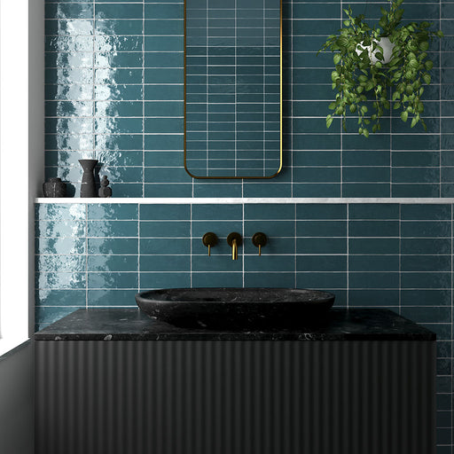 Zellij Peacock Green brick tiles, 6.5cm x 20cm, Moroccan style glazed ceramic wall tiles in deep peacock green tones with subtle tonal variation, glossy finish, and handcrafted texture, shown in a modern bathroom sink setting.