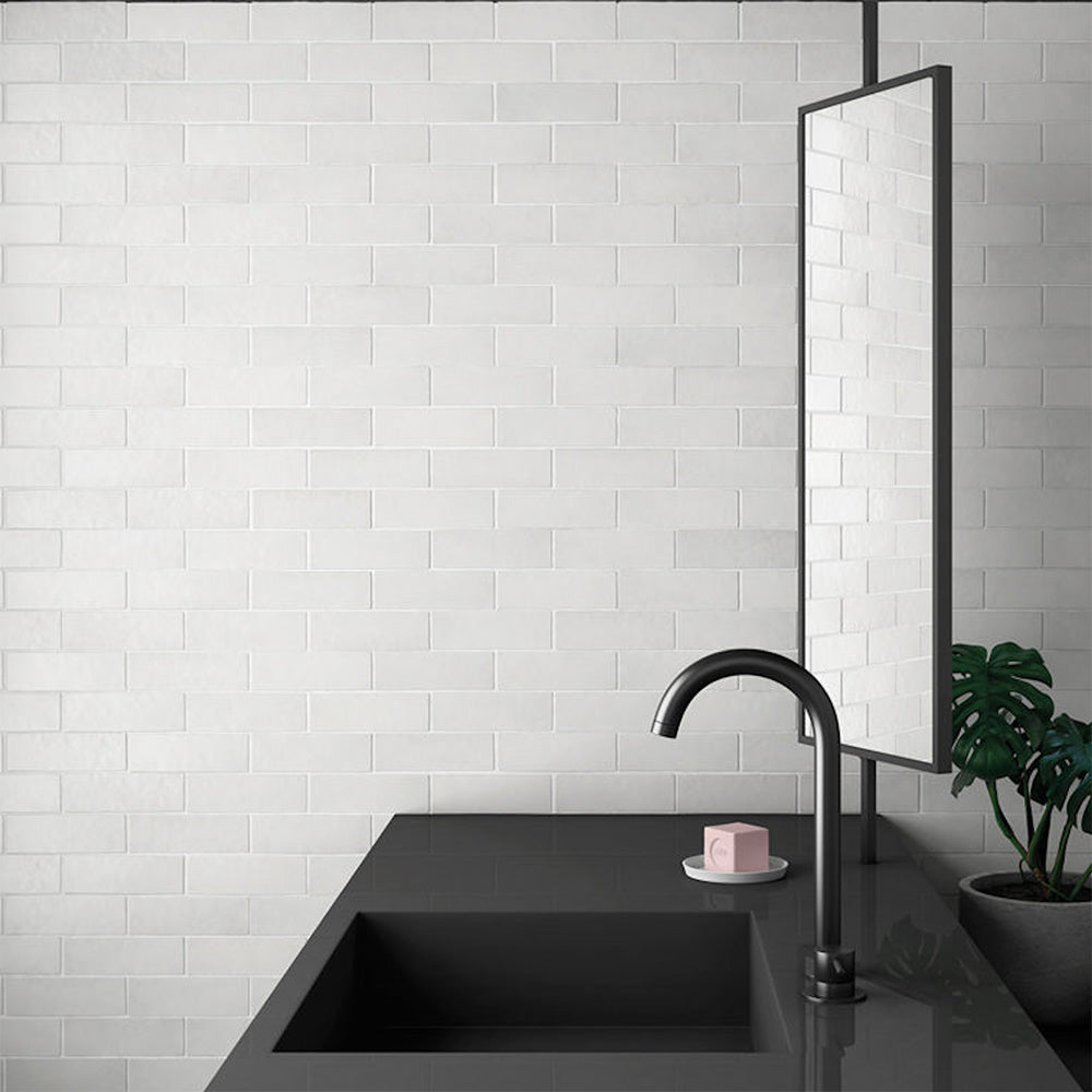 Bathroom sink setting featuring Zellij Chalk White Brick Moroccan-style tiles in a 6.5cm x 20cm format, with a soft matt white finish and subtle handmade texture, styled with a minimalist black basin, wall-mounted tap, and modern mirror.