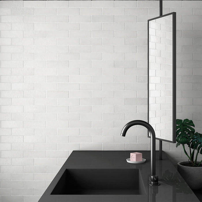 Bathroom sink setting featuring Zellij Chalk White Brick Moroccan-style tiles in a 6.5cm x 20cm format, with a soft matt white finish and subtle handmade texture, styled with a minimalist black basin, wall-mounted tap, and modern mirror.