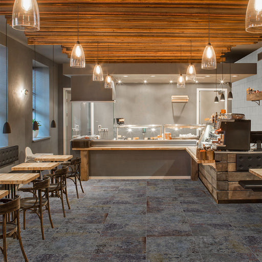 Commercial interior featuring Boheme Sinora 60 × 60cm patterned porcelain floor tiles, blending deep blue, grey and rust tones with a layered, aged-effect finish. Creates a rich, industrial-inspired look suited to contemporary spaces.