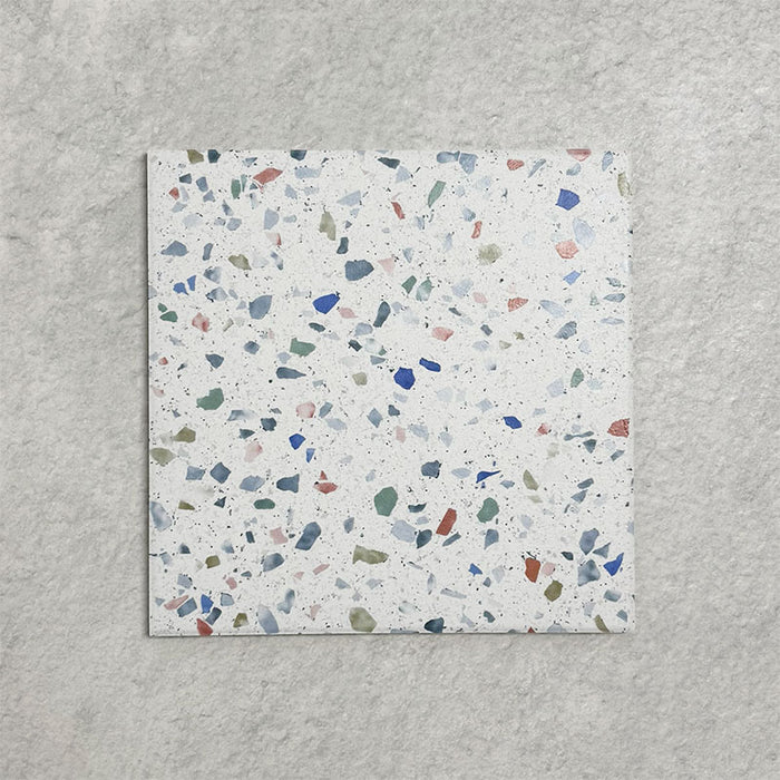 Single Confetti Tutti Frutti 25×25cm terrazzo-style porcelain tile featuring colourful multitone chips on a white base, displayed against a light textured background.