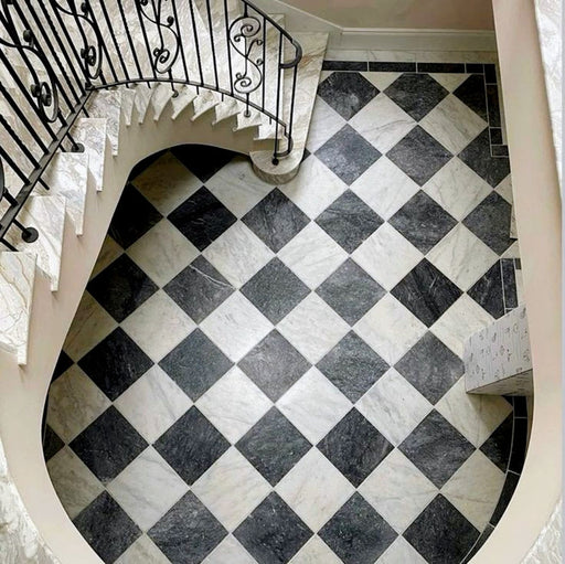 Staircase interior featuring Fitzrovia Black 15.2x15.2cm honed natural marble tiles paired with white marble in a classic chequerboard floor, showcasing elegant contrast, natural veining, and a timeless, architectural setting.