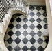 Staircase interior featuring Fitzrovia Black 15.2x15.2cm honed natural marble tiles paired with white marble in a classic chequerboard floor, showcasing elegant contrast, natural veining, and a timeless, architectural setting.