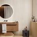 Modern bathroom featuring Storico Travertine Stone matt porcelain wall tiles with a soft travertine effect finish, complemented by a floating vanity, round illuminated mirror, oak cabinetry and warm neutral tones for a calm, spa-inspired space.