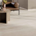 Close-up of Storico Travertine Stone matt porcelain floor tiles with a soft travertine effect finish, styled alongside warm wood furniture, leather seating and neutral décor to create a timeless, contemporary living space.