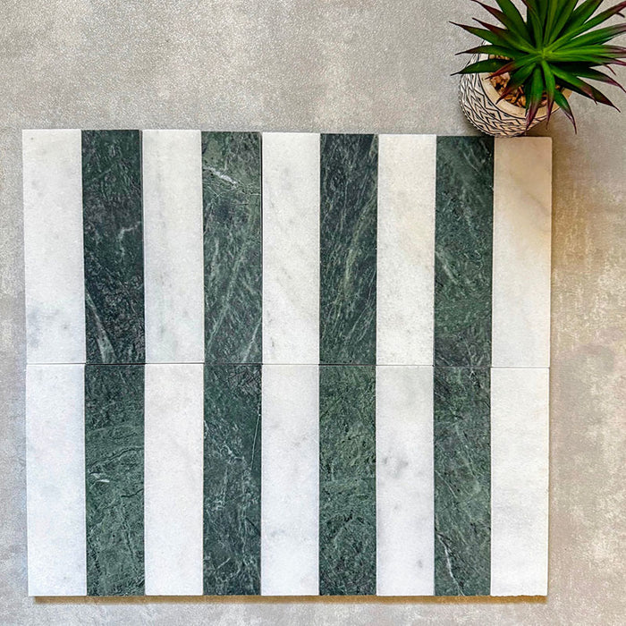 Flat lay of Fitzrovia White 5x20cm honed natural marble brick tiles paired with green marble in a striped layout, showcasing soft white tones, rich green contrast, and natural veining in a linear design.