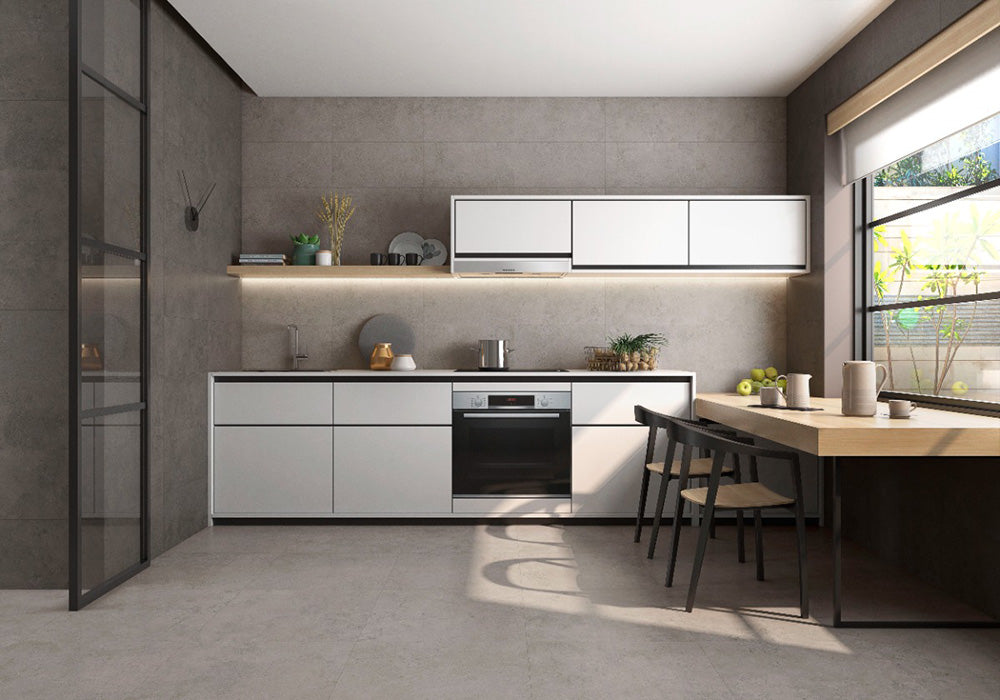 Kitchen interior featuring Tane Stone Grey Matt 30 × 60cm porcelain wall and floor tiles, styled with white cabinetry, warm wood accents, open shelving, and natural light for a modern, balanced, contemporary space.