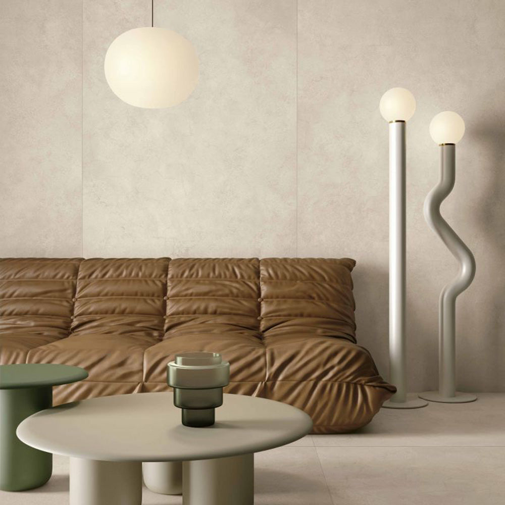 Living room featuring Tane Stone Marfil Matt 60 × 120cm porcelain floor tiles, styled with a leather sofa, sculptural lighting, and soft neutral tones for a warm, contemporary, design-led space.