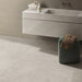 Bathroom interior featuring Tane Stone Pearl Matt 60 × 60cm porcelain floor tiles, styled with a floating vanity, soft neutral tones, and minimal décor for a calm, contemporary finish.