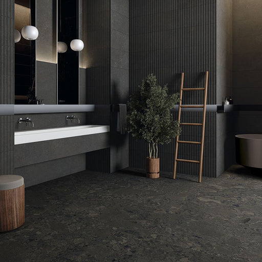 Modern bathroom featuring Terrace Terrazzo Black 60x60cm porcelain tiles on the floor and walls. The dark charcoal terrazzo effect creates a bold, contemporary look, paired with fluted wall panels, a floating white vanity, timber accents and soft globe lighting for a sophisticated, luxurious finish.