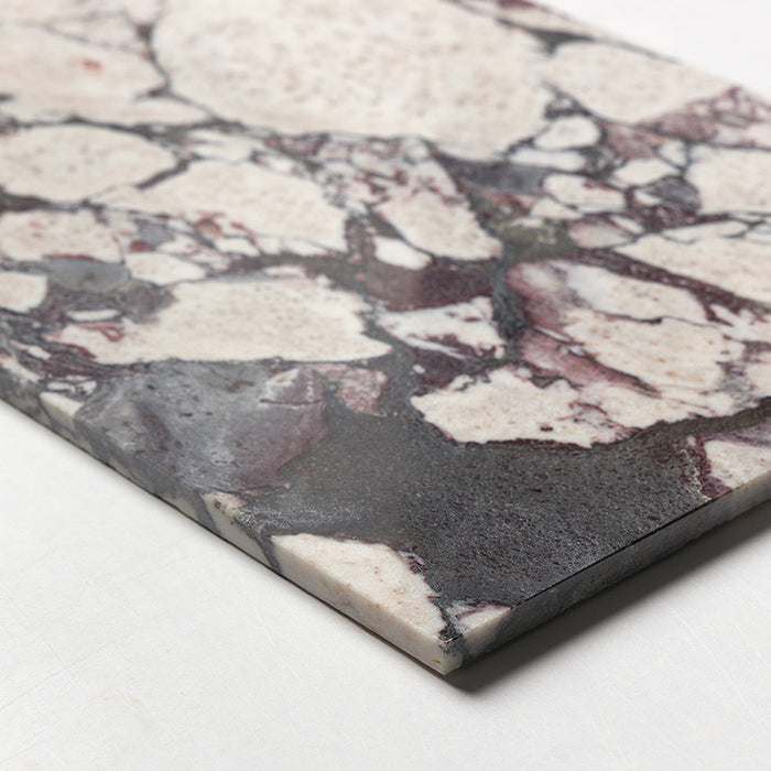 Close-up of Fitzrovia Viola 30.5x61cm natural marble tile with a honed finish, showcasing a rich mix of white, burgundy and deep grey tones, highlighting the texture, edge detail and natural variation of the stone.