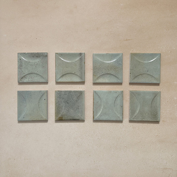 Beijing Celadon Green Decor Square 10x10cm Moroccan-style ceramic wall tiles, styled on a neutral beige background to highlight their raised circular pattern and glossy glaze.