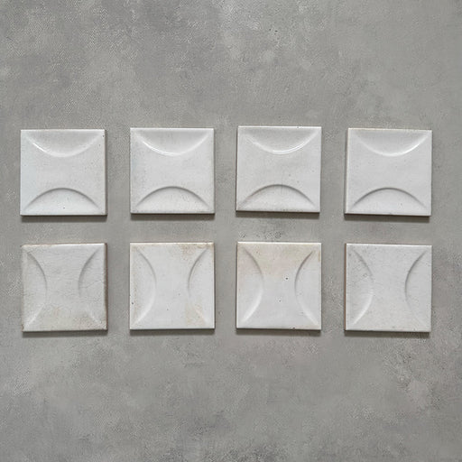Selection of Beijing White Décor 10x10cm Moroccan square tiles showcasing their soft white glaze and raised crescent pattern, highlighting handcrafted texture and natural surface variation.