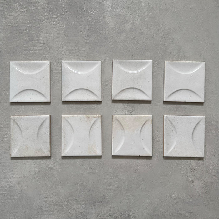 Selection of Beijing White Décor 10x10cm Moroccan square tiles showcasing their soft white glaze and raised crescent pattern, highlighting handcrafted texture and natural surface variation.