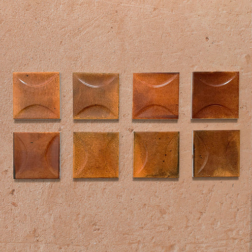 Beijing Amber Decor Square 10x10cm Moroccan-style ceramic wall tiles, styled on a warm textured background to highlight their curved relief design and glossy amber finish.