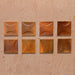 Beijing Amber Decor Square 10x10cm Moroccan-style ceramic wall tiles, styled on a warm textured background to highlight their curved relief design and glossy amber finish.