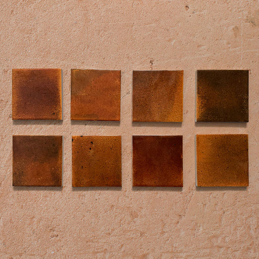 Beijing Amber Square 10x10cm Moroccan-style ceramic wall tiles, styled on a warm textured background to highlight their rich amber tones and glossy handcrafted finish.
