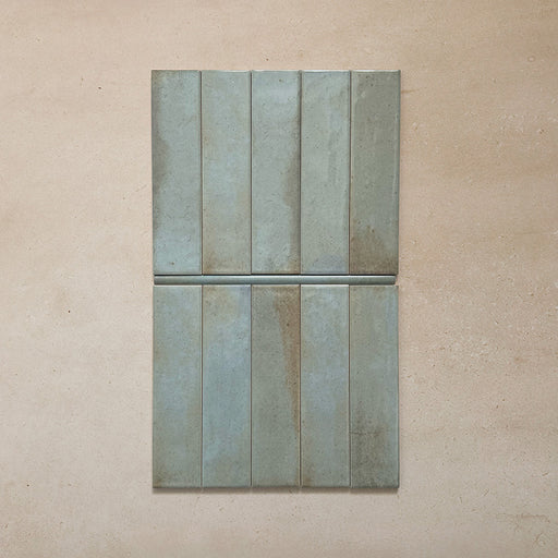 Izmir Celadon Green Gloss Pencil Bullnose Border Tile 1.2x30cm shown with matching 6x25cm brick tiles on a neutral beige background, highlighting the curved border edge and glossy handcrafted finish.