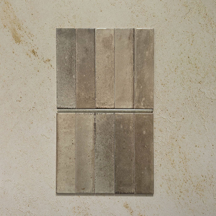 Izmir Sage Green Gloss Pencil Bullnose Border Tile 1.2x30cm shown with matching 6x25cm brick tiles on a textured beige background, highlighting the glossy handcrafted finish and curved border edge.