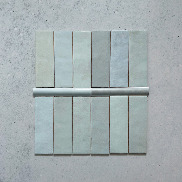 Zellij Aqua Blue Brick Moroccan Style tiles with bullnose trim, 6.5cm x 20cm, rectangular brick format, soft aqua blue tones with subtle tonal variation, glossy glazed finish, handcrafted Moroccan-inspired design shown with matching bullnose detail.