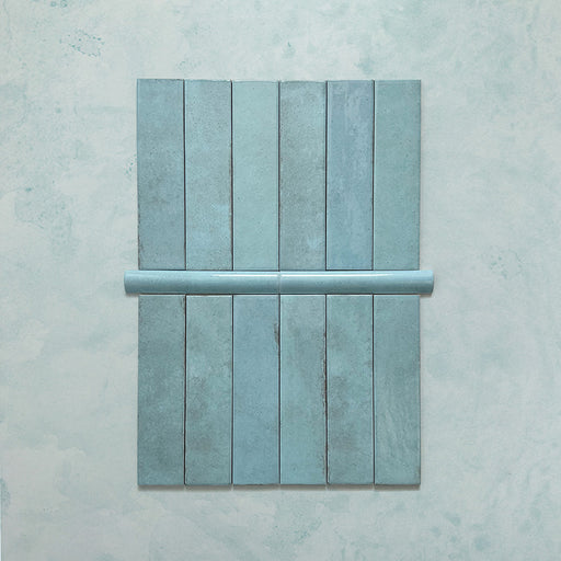 Madison Aquamarine Bullnose Pencil Border Tiles 3x20cm — shown with matching brick tiles, this elegant border piece completes the look with a soft, curved edge. The glossy teal glaze adds a polished finish, ideal for framing tiled walls or creating refined transitions in kitchens and bathrooms.