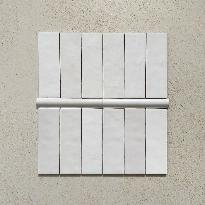 Zellij White Gloss Brick Moroccan-style tiles in a 6.5cm x 20cm brick format, paired with a matching bullnose trim, featuring a glossy white glaze and subtle handmade surface variation, displayed as a flat lay on a neutral background.