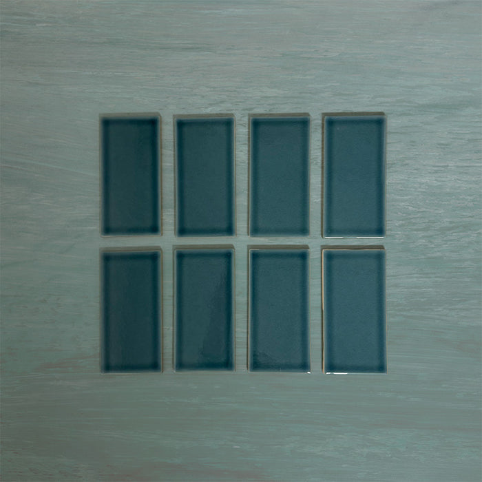 Flat lay of Finchley River Blue 7.5 × 15cm ceramic tiles with a crackle glaze finish, highlighting rich blue tones, subtle surface texture and tonal variation for elegant wall tile designs.