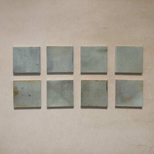 Beijing Celadon Green Square 10x10cm Moroccan-style ceramic wall tiles, styled on a neutral beige background to highlight their soft glaze and handcrafted variation.