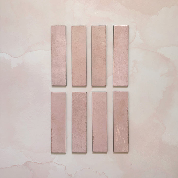 Madison Rose Brick Wall Tiles 6x24.6cm — individual tile selection highlighting the delicate blush pink tones and handcrafted finish. Each piece showcases subtle shade variations and a soft gloss surface, perfect for adding warmth and charm to kitchens and bathrooms.
