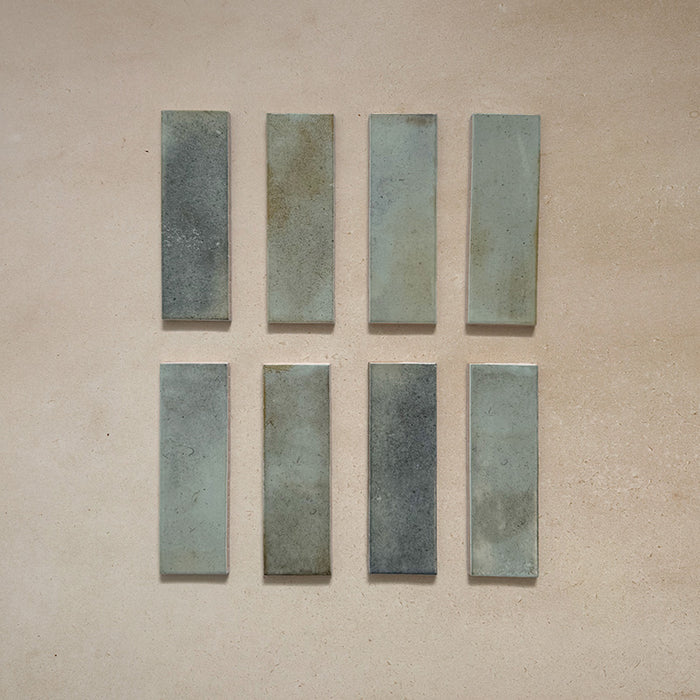 Beijing Celadon Green Brick 5.1x16.1cm Moroccan-style ceramic wall tiles, styled on a neutral beige background to highlight their natural glaze variations.