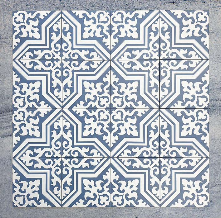 Group of Europa Trondheim Blue 20x20cm Victorian Moroccan style tiles arranged together to showcase the repeating decorative pattern in blue and white tones, displayed against a textured grey background.