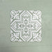 Four Europa Trondheim Sage Green 20x20cm Victorian Moroccan style tiles arranged together to showcase the repeating decorative pattern in sage green and white tones, displayed against a textured green background.