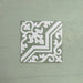 Single Europa Trondheim Sage Green 20x20cm Victorian Moroccan style tile displayed against a textured green background, featuring a decorative geometric and floral pattern in sage green and white tones in a close-up product setting.