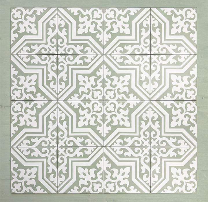 Group of Europa Trondheim Sage Green 20x20cm Victorian Moroccan style tiles arranged together to showcase the repeating decorative pattern in sage green and white tones, displayed against a textured green background.