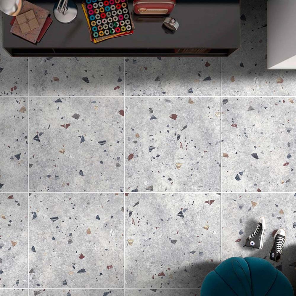 Top-down interior view featuring Tulsa Silver Terrazzo 66 × 66cm porcelain wall and floor tiles, showcasing a soft grey base scattered with multicoloured aggregate chips, styled with modern furnishings for a clean, contemporary finish.
