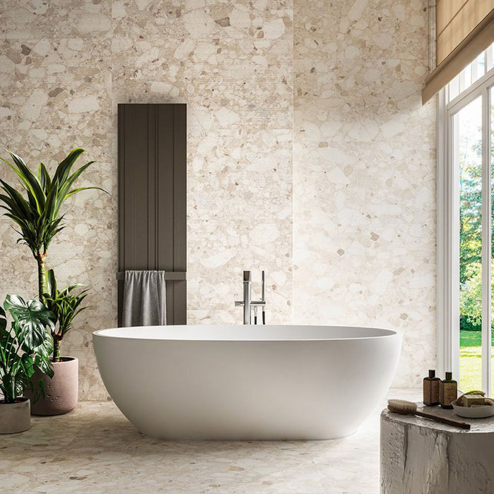 Spa-inspired bathroom featuring Venetian Ivory 60cm x 120cm terrazzo effect matt porcelain wall and floor tiles, paired with a freestanding bath, textured feature wall, indoor plants and soft natural light.