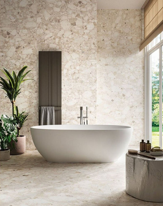 Spa-inspired bathroom featuring Venetian Ivory 60cm x 120cm terrazzo effect matt porcelain wall and floor tiles, paired with a freestanding bath, textured feature wall, indoor plants and soft natural light.