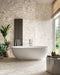 Spa-inspired bathroom featuring Venetian Ivory 60cm x 120cm terrazzo effect matt porcelain wall and floor tiles, paired with a freestanding bath, textured feature wall, indoor plants and soft natural light.