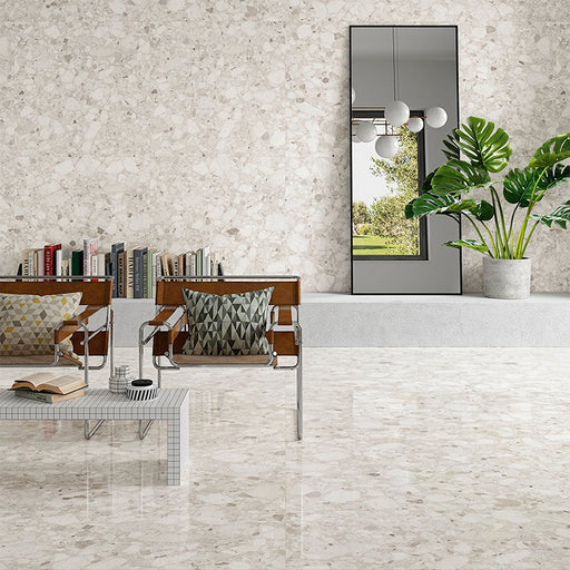 Modern living room featuring Venetian Ivory 60cm x 60cm terrazzo effect polished porcelain wall and floor tiles, creating a bright, seamless interior with contemporary furniture, indoor plants and elegant stone-inspired detailing.