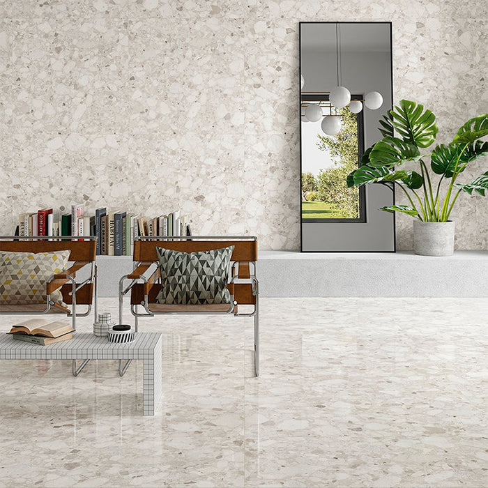 Modern living room featuring Venetian Ivory 60cm x 60cm terrazzo effect polished porcelain wall and floor tiles, creating a bright, seamless interior with contemporary furniture, indoor plants and elegant stone-inspired detailing.