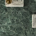 Bathroom interior featuring Grand Verde Apia Polished Green Marble effect 60 × 60cm porcelain wall and floor tiles, styled with a floating vanity, brass basin, and rich green tones with intricate natural veining.
