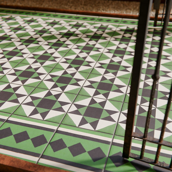 Maison Green Decor Victorian Pattern 20cm x 20cm walkway setting, Victorian-style patterned floor tiles laid in a geometric diamond design, rich green, black and white colour palette, matt finish with decorative border detailing, classic heritage-inspired design used in an outdoor entrance walkway.