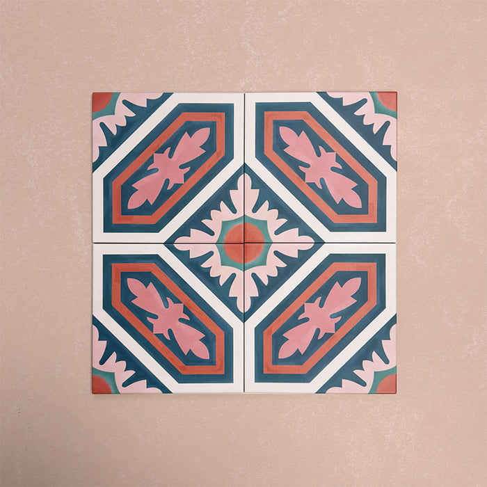 Four Europa Vienna 20x20cm Victorian Moroccan style tiles arranged together to showcase the repeating geometric pattern in blue, pink and coral tones, displayed against a soft pink background.