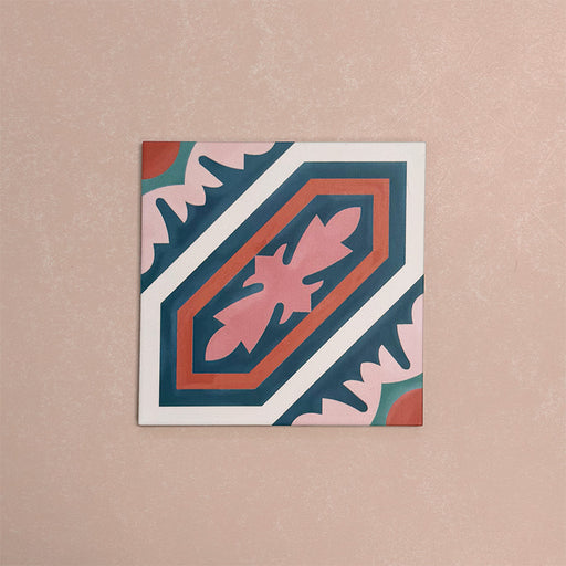 Single Europa Vienna 20x20cm Victorian Moroccan style tile displayed against a textured pink background, featuring a decorative geometric and floral pattern in blue, pink and coral tones in a close-up product setting.