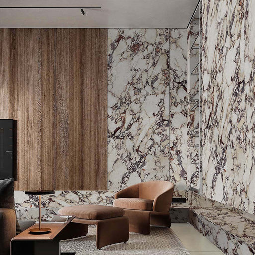 Living area featuring Grand Violetta Matt Honed Marble effect 60 × 60cm porcelain wall and floor tiles, styled with warm wood panelling, leather seating, and bold veining creating a rich, design-led space.