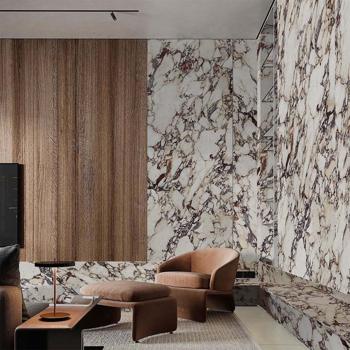 Living area featuring Grand Violetta Matt Honed Marble effect 60 × 60cm porcelain wall and floor tiles, styled with warm wood panelling, leather seating, and bold veining creating a rich, design-led space.