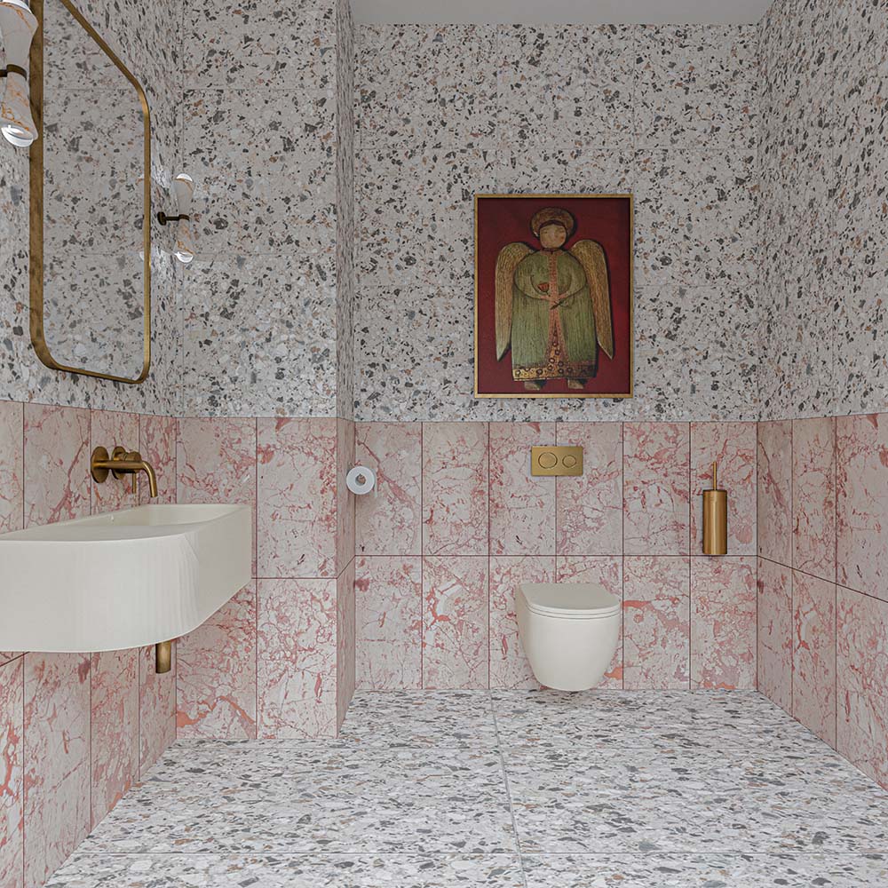 Vito Moonstone 60cm x 60cm terrazzo effect tiles, featuring a speckled mix of soft grey, charcoal and warm earthy tones across the bathroom floor and walls, paired with pink marble effect tiles and brass details.