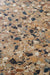 Close-up of the Vito Umbar 60x120cm terrazzo style porcelain tile, highlighting its rich amber-brown base with a blend of ochre, cream, rust, charcoal and soft grey stone fragments. The realistic 4D brushed finish enhances the texture and depth, creating an authentic terrazzo effect.