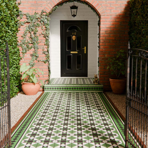 Maison Green Decor Victorian Pattern 20cm x 20cm walkway setting, Victorian-style patterned floor tiles laid in a geometric diamond design, rich green, black and white colour palette, matt finish with decorative border detailing, classic heritage-inspired design used in an outdoor entrance walkway.