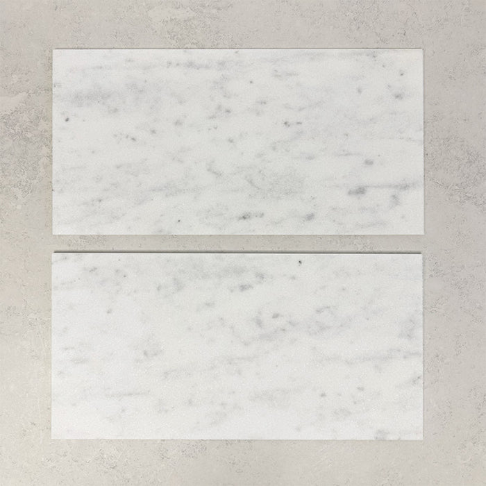 Close-up of Fitzrovia White natural marble tiles in a honed finish, 30.5x61cm format, showcasing a soft white base with gentle grey veining and subtle tonal variation, creating a timeless and refined look for wall and floor applications.